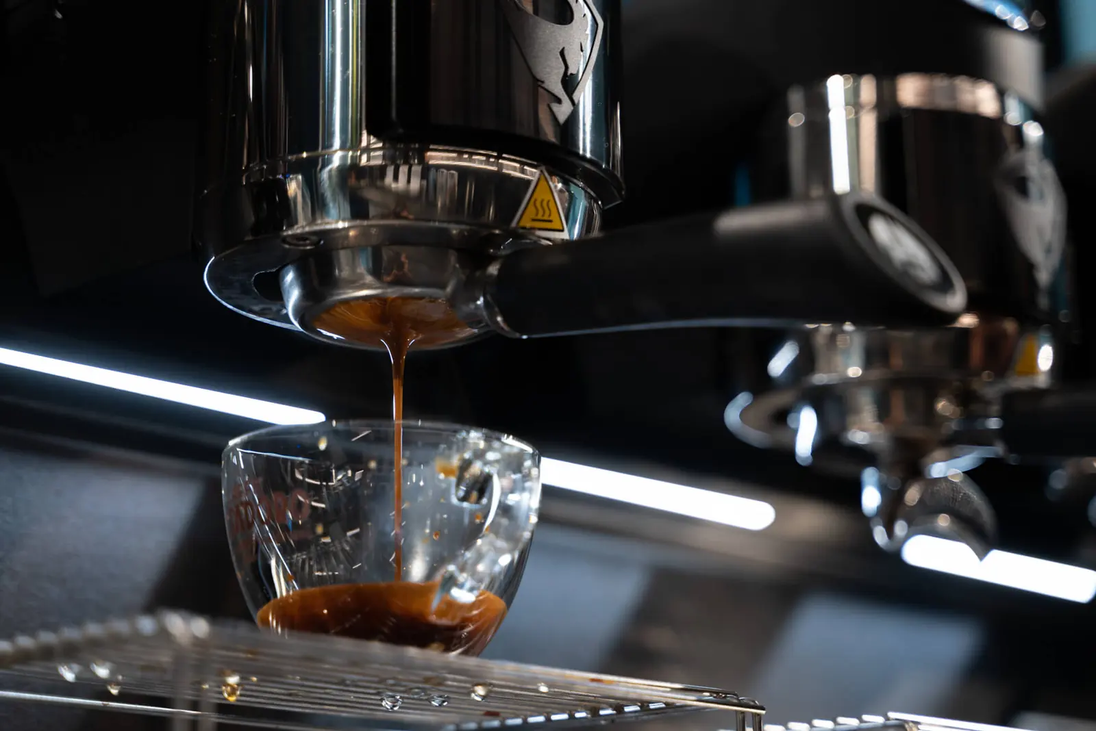 Espresso pouring into a glass from a Sanremo Café Racer